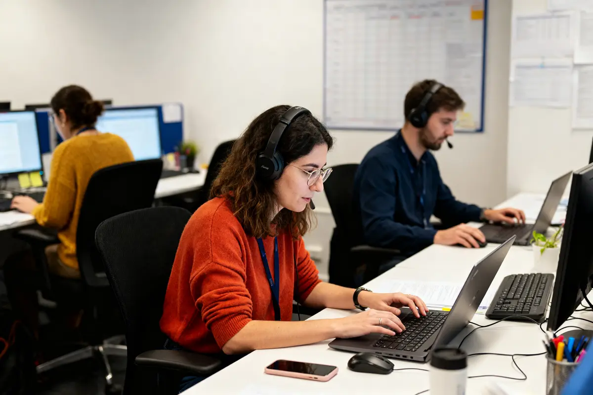 Employés travaillant avec casques sur ordinateurs dans une translation agency 推薦 moderne et dynamique