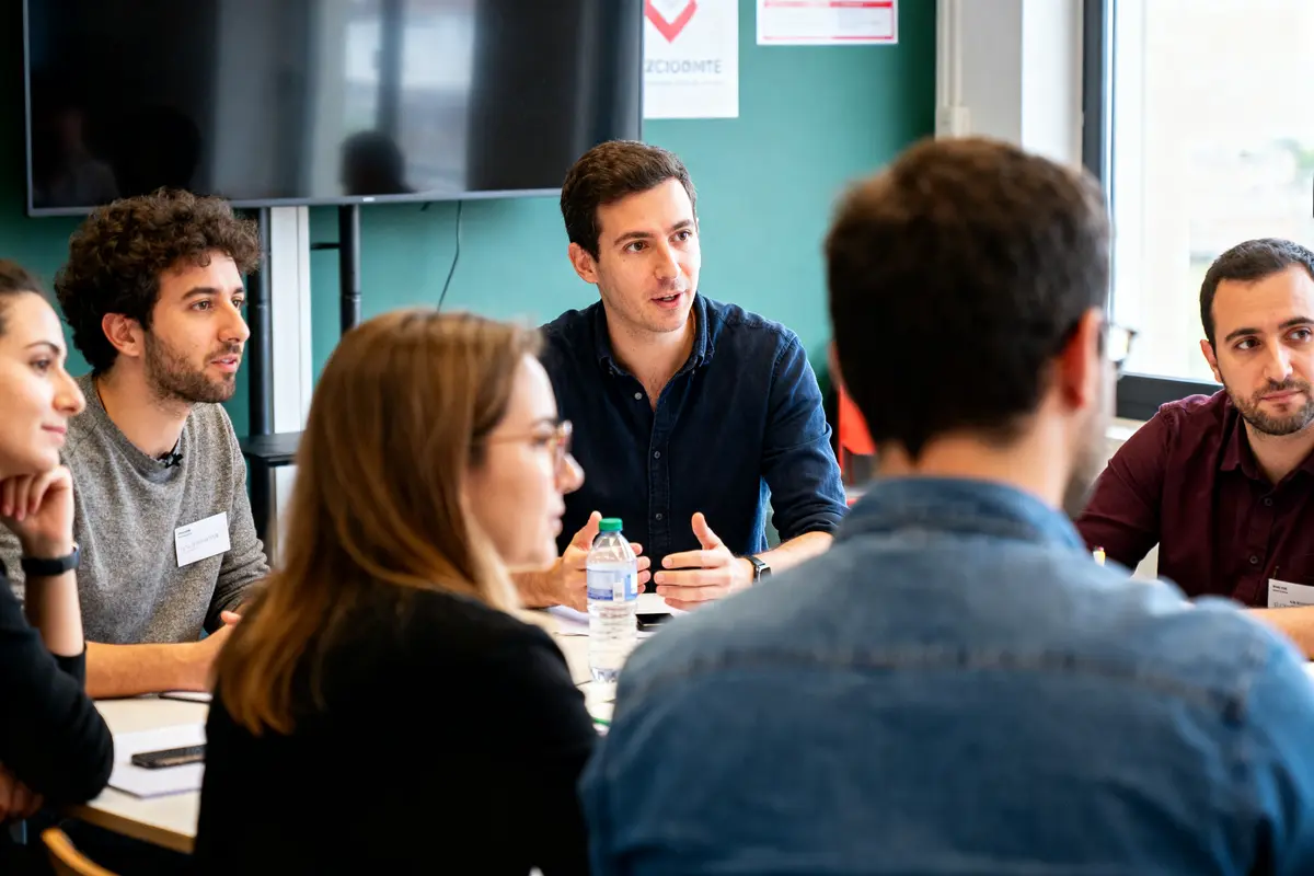 Groupe de personnes discutant stratégie durant une formation ecommerce en salle de réunion.